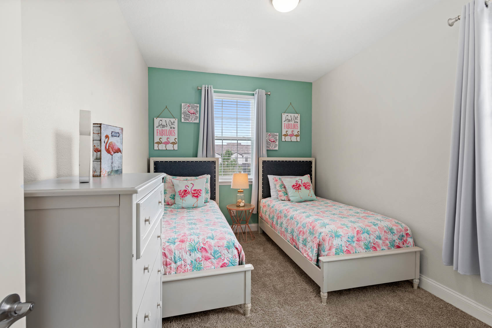 bedroom with double beds and teal wall